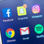 Smartphone-Bildschirm mit den App-Symbolen von Facebook, Snapchat (mit Benachrichtigung), Instagram, Twitter, Chrome, Gmail, Spotify und Messenger.