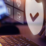 Ein Laptop mit darüber schwebenden digitalen Icons für Versicherungen (Haus, Gesundheit, Auto, Reise) und einem zentralen Schutzschild-Symbol mit Haken.