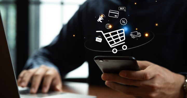 Eine Person tippt auf einem Smartphone; darüber schwebt eine digitale Grafik eines Einkaufswagens mit verschiedenen Symbolen, die Online-Shopping visualisieren.