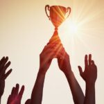 Hand hebt Pokal hoch