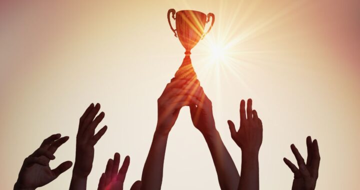 Hand hebt Pokal hoch