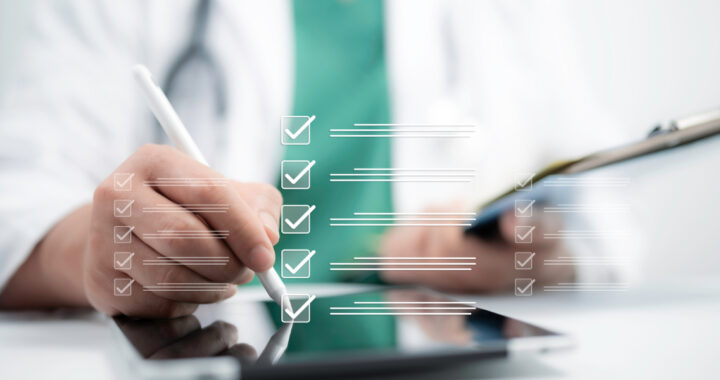 Eine digitale Grafik einer Checkliste mit abgehakten Kästchen schwebt über einem Tablet im Vordergrund. Ein Arzt im unscharfen Hintergrund, bekleidet mit weißem Kittel, grünem Kasack und Stethoskop, bearbeitet die Liste mit einem digitalen Eingabestift.