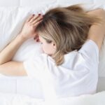 Frau liegt schlafend im Bett