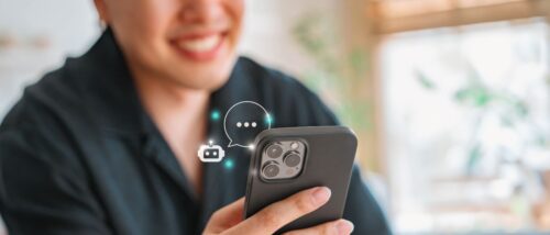 Person hat ein Handy in der Hand und Robotersymbol stellt dar, dass die Person mit einem Chatbot schreibt